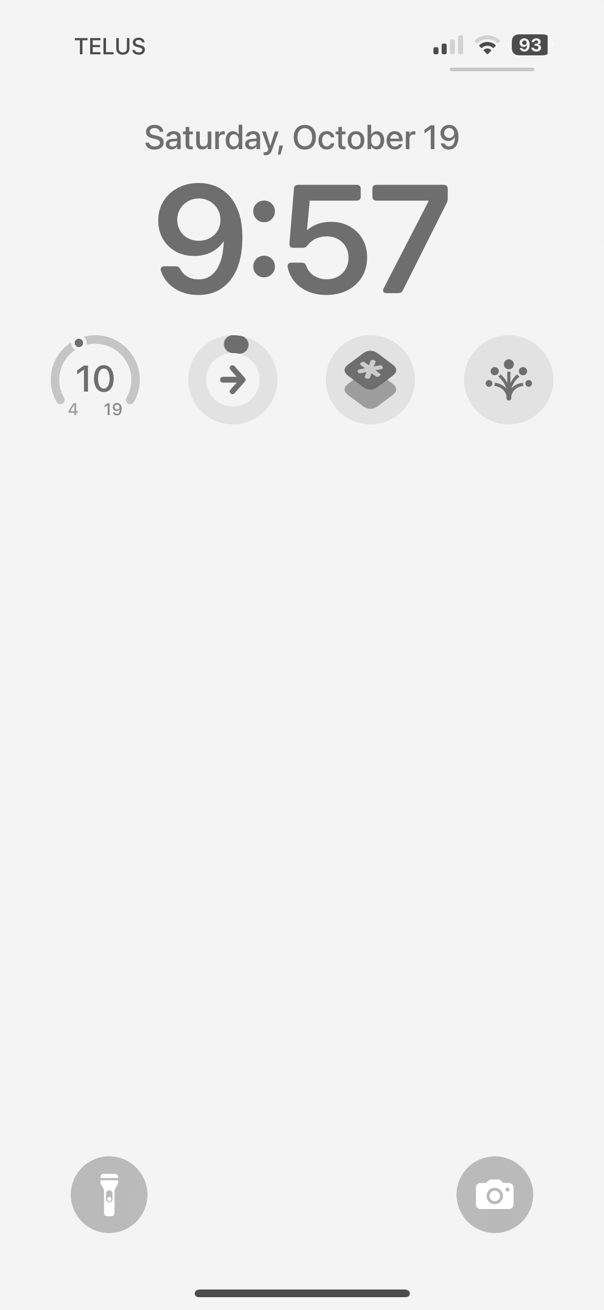 A smartphone lock screen displays “Saturday, October 19” at 9:57. Top left shows “TELUS” and top right has icons for Wi-Fi, battery at 93%, and signal strength. The bottom features flashlight and camera shortcuts